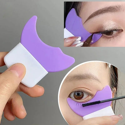 Purple silicone eyeliner template applicator held in hand, shown in use as a mascara shield and eye makeup aid for precise eyelid and lash makeup application.