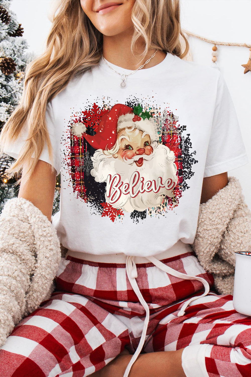 White crewneck T-shirt with Believe Christmas Father graphic and plaid background